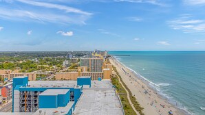 A coastal cityscape with a beach, high-rise buildings, and a clear sky. - The Palace 505 (Myrtle Beach)