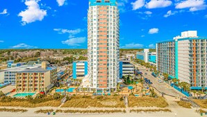 A high-rise hotel with multiple floors, a rooftop pool, and a beachside location. - The Palace 1404 (Myrtle Beach)