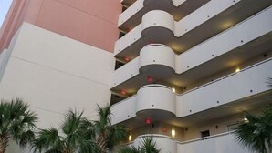 A multi-story hotel with a distinctive curved facade and balconies. - Bay Watch 1438 (North Myrtle Beach)