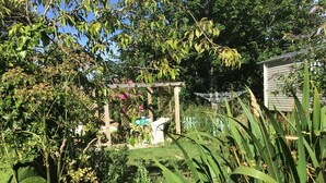 A garden with various plants and a pergola structure. - 1bed Cottage Sleeps 2 - Enclosed Garden, Pets, Bbq (Helston)