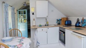 A compact kitchen with white cabinetry, a sink, a toaster, and a kettle. - 1bed Cottage Sleeps 2 - Enclosed Garden, Pets, Bbq (Helston)