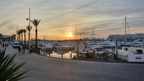A marina with boats docked, a road with pedestrians, and palm trees. - Space and comfort in beautiful Vilamoura, Algarve, Portugal  (Vilamoura)