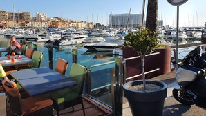 A marina with boats, a dining area with tables and chairs, and a no parking sign. - Space and comfort in beautiful Vilamoura, Algarve, Portugal  (Vilamoura)