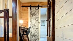 A wooden interior with a staircase leading to a room with a desk and chair. - Appartement Lila (Carcassonne)