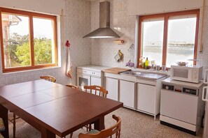 Enjoy meals in this kitchen with a central island, dining table, and stove.