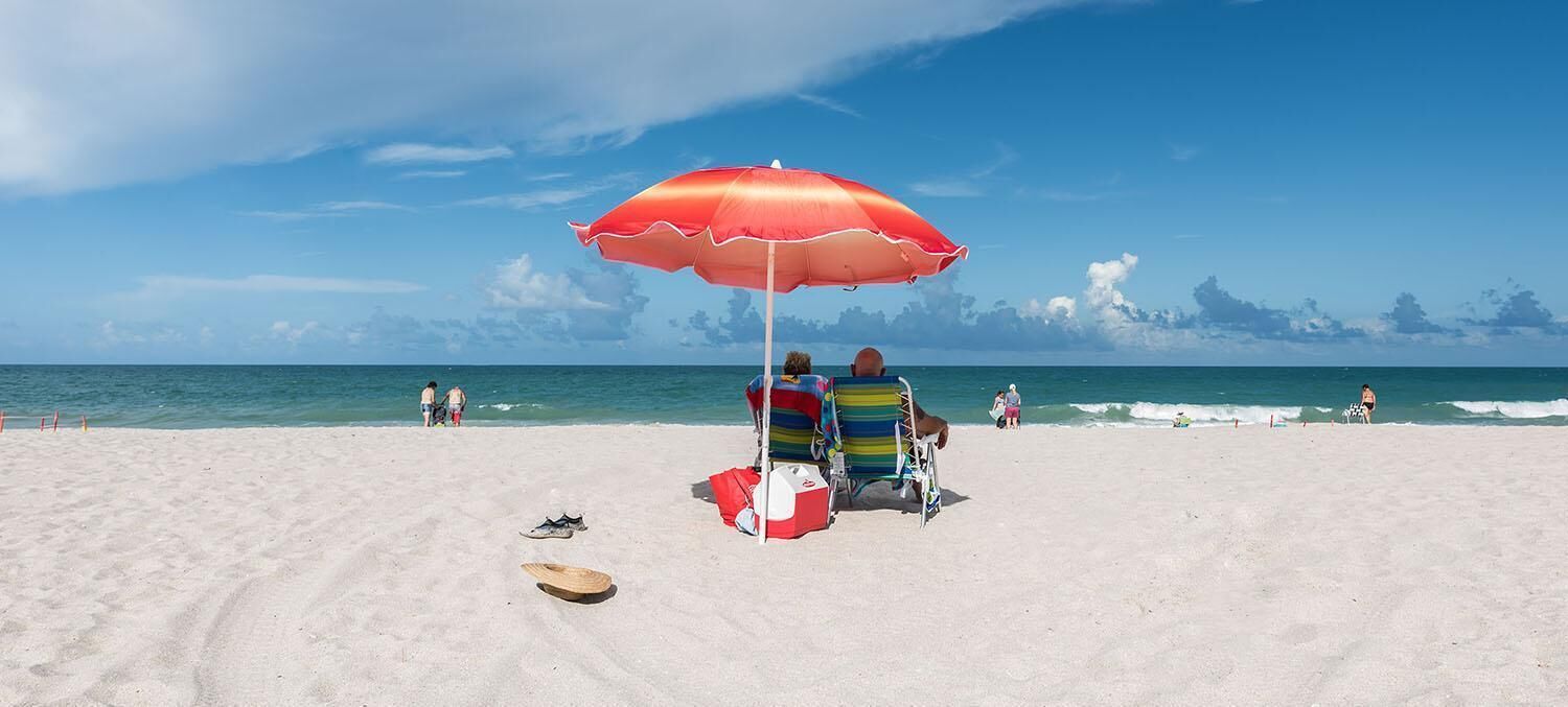 on the beach, white sand, beach umbrellas, beach towels