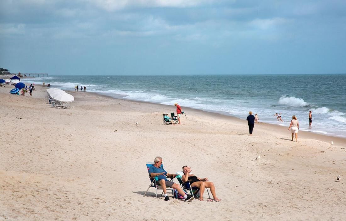on the beach, white sand, beach umbrellas, beach towels