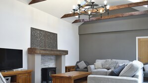 Una sala de estar con chimenea, televisión y sofá.