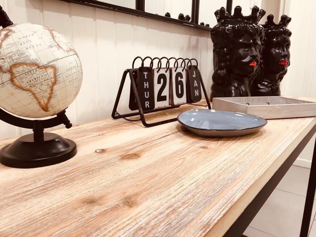 Un tavolo in legno con un mappamondo, un calendario e oggetti decorativi.