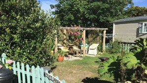 Um jardim privativo com pérgola, móveis de exterior e uma placa com a inscrição 'PRIVATE GARDEN'.