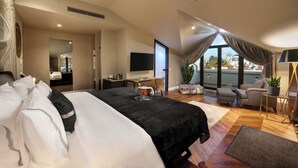 Um quarto espaçoso com uma cama grande, uma escrivaninha, uma TV e uma varanda com vista.