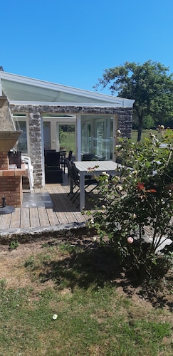 Charmantes Ferienhaus mit einer nach Süden ausgerichteten Veranda mit Blick auf einen Obstgarten.