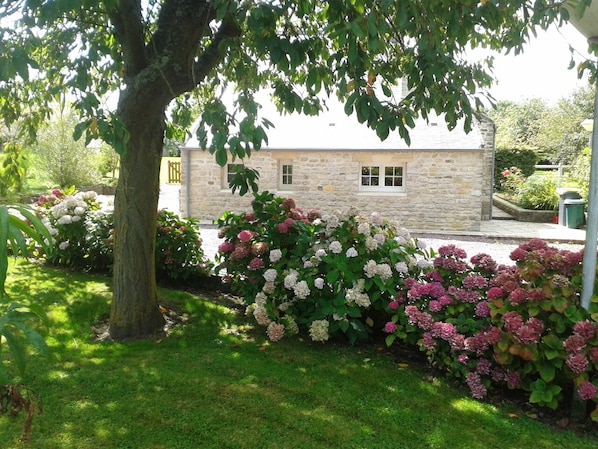 A stone building with a garden in front.