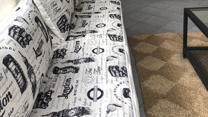 A living room with a sofa, a flat-screen TV mounted on the wall, and a woven rug on the floor. - Amplio & Luminoso Depto Centro de Salta (Salta)