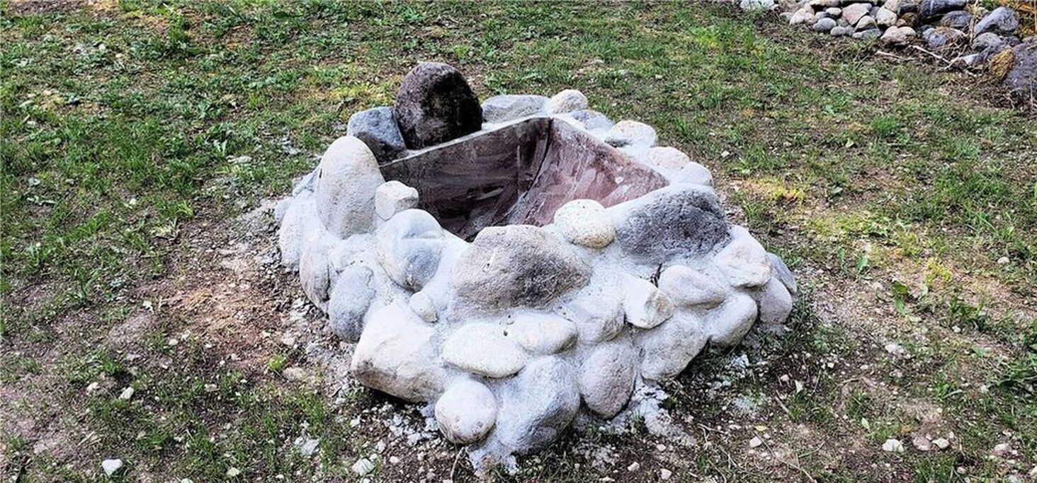 Un hogar de piedra rodeado de rocas.