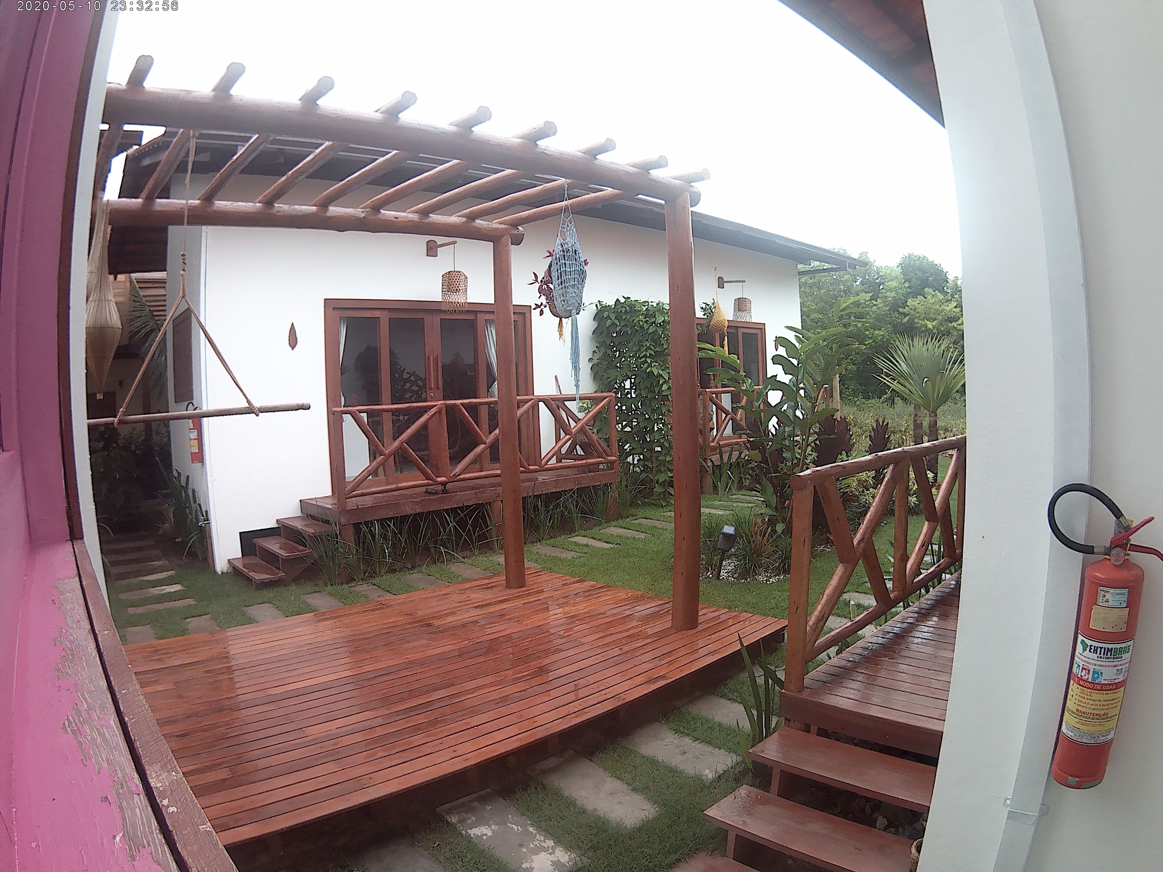 Una terraza de madera con escalones que conducen a un edificio blanco con una ventana y una puerta.