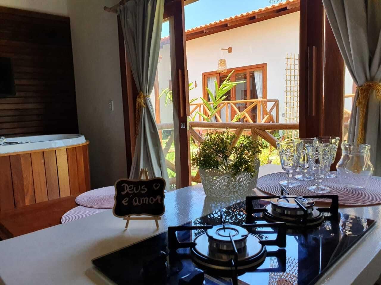A cozy dining area with a table set for two, a gas stove, and a view of the outdoor patio.