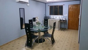 Une cuisine de taille réduite avec un coin repas, un ventilateur de plafond et une fenêtre.