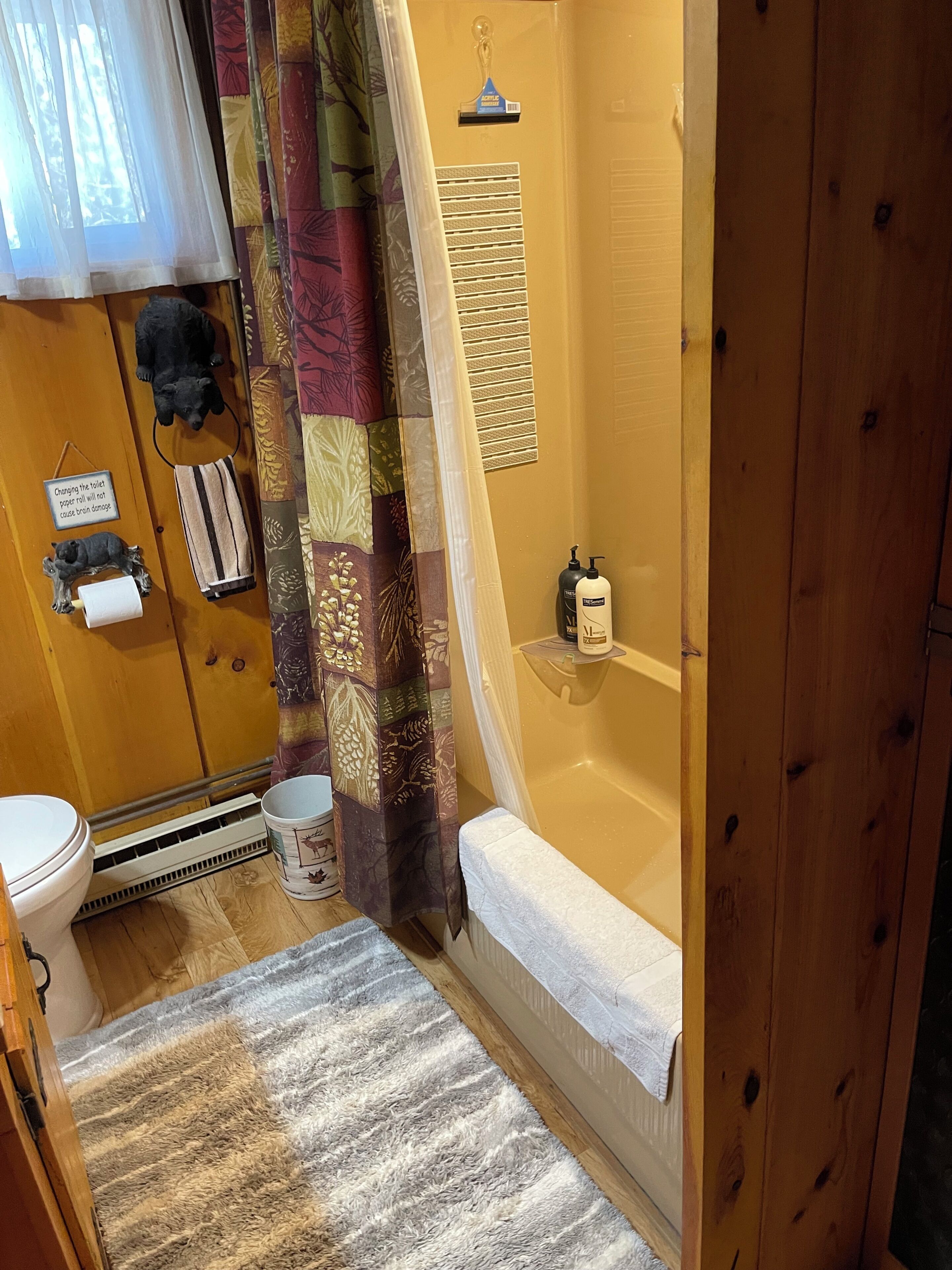 A bathroom with a bathtub, toilet, and shower curtain.