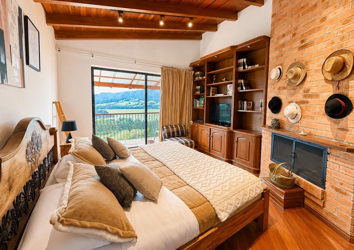 Un dormitorio con una cama grande, cabecera de madera, televisor, estanterías y chimenea.