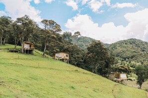 Une colline parsemée de chalets en bois, entourée d’arbres et de collines.