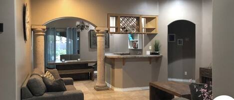 A modern living room with a sofa, a coffee table, and a dining area with a bench.