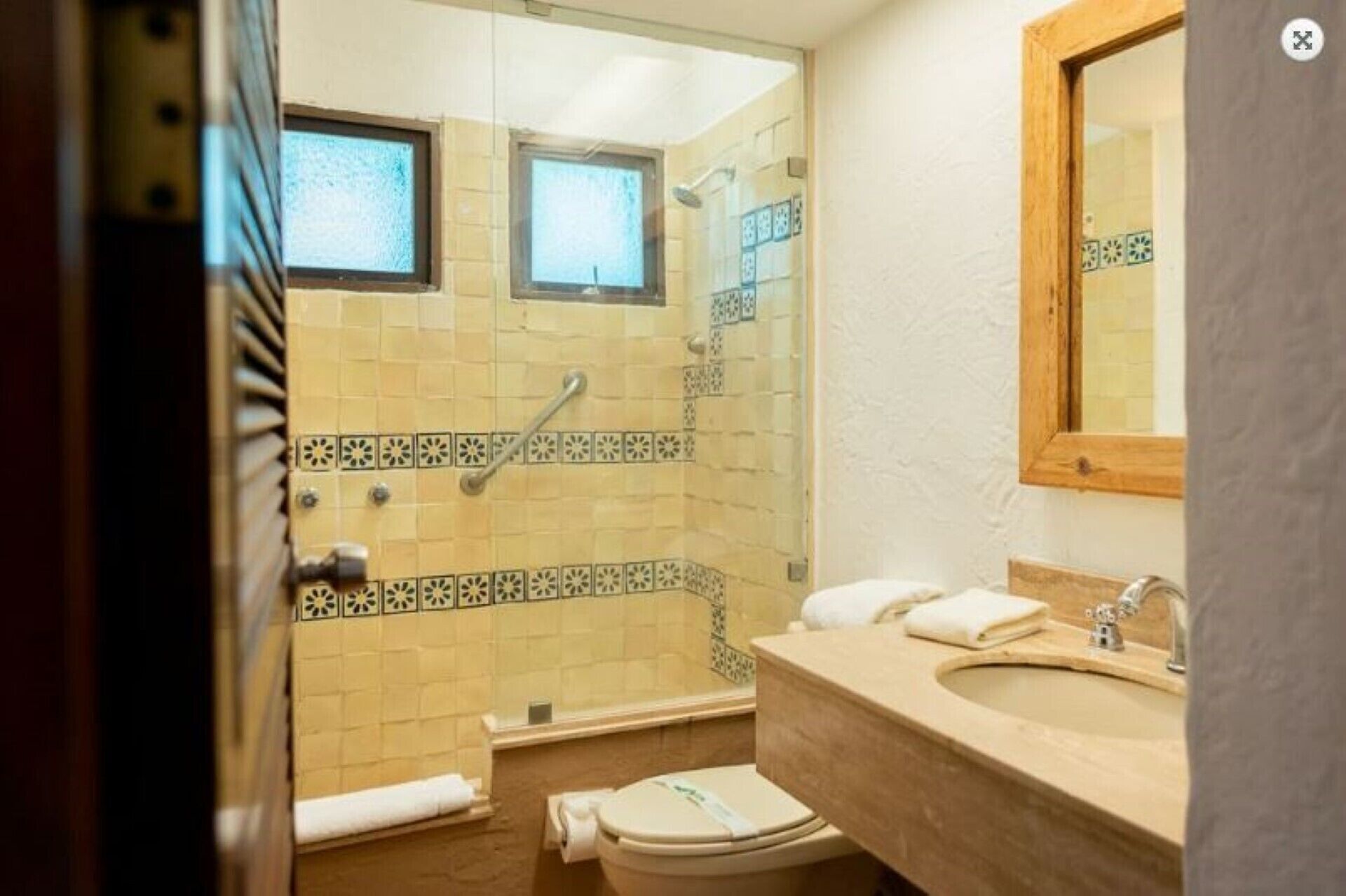 A bathroom with a shower, toilet, and sink.