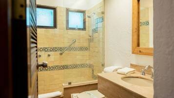 A bathroom with a shower, toilet, and sink.