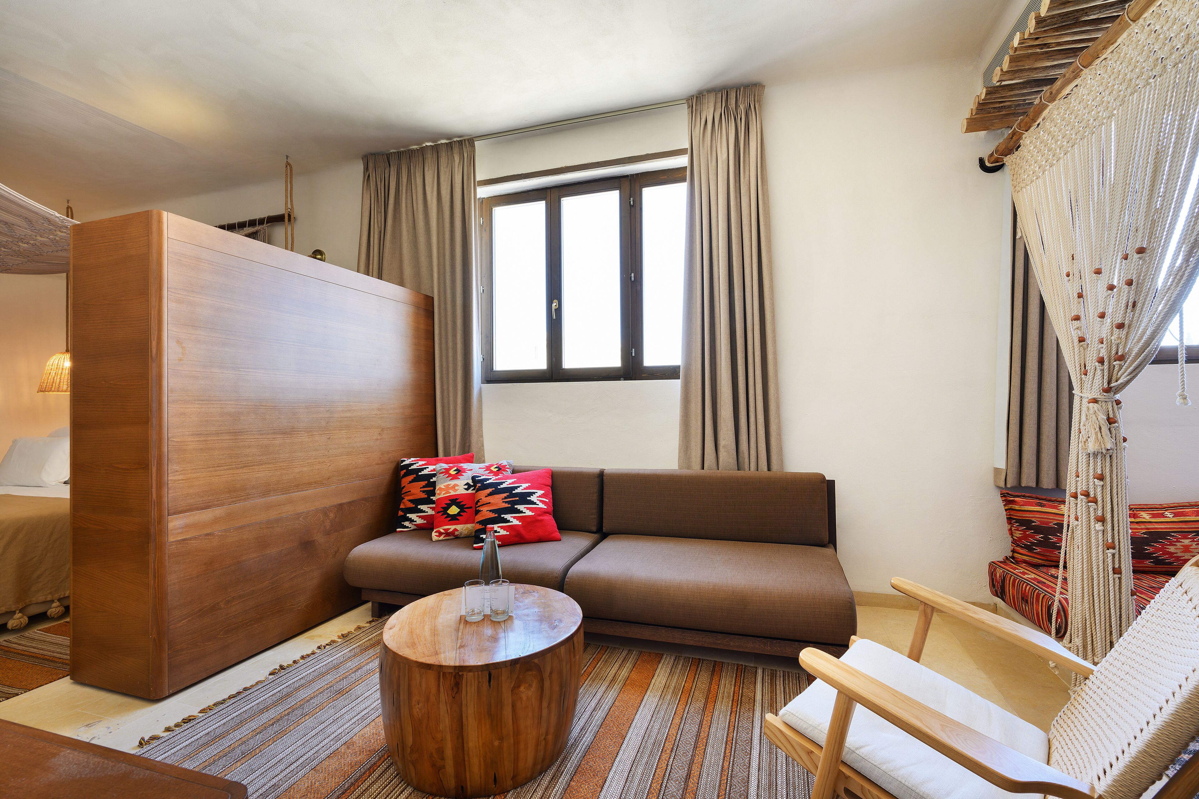 A modern living room with a sofa, a wooden coffee table, a chair, and a large wardrobe.