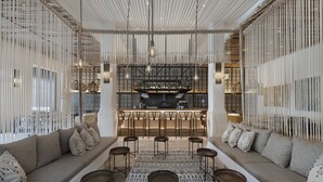 A modern interior with a bar area, seating, and a patterned rug. - Kedma by Isrotel Design (Ramat Negev)