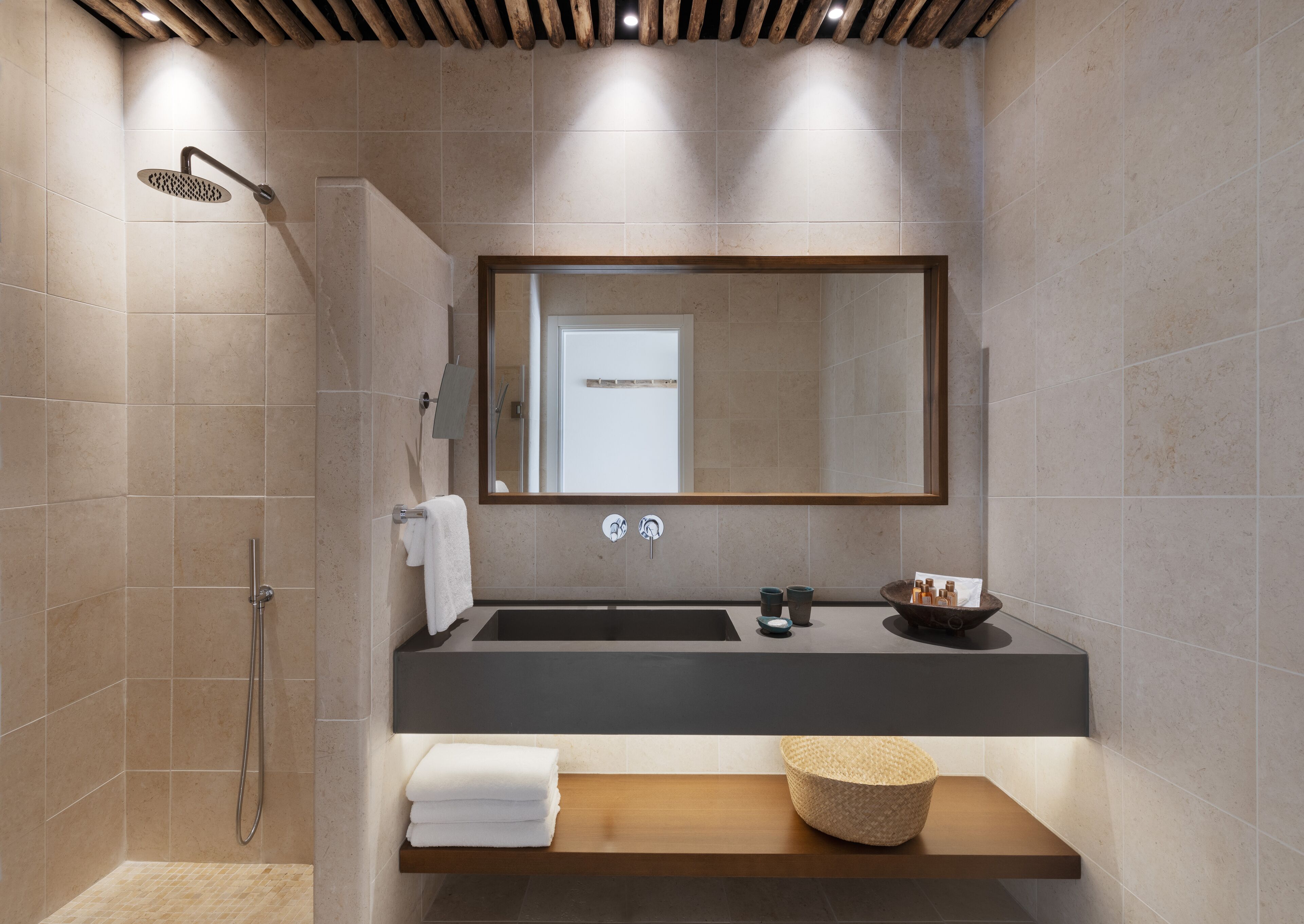 A modern bathroom with a shower, a sink, and a mirror.