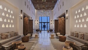 A spacious lobby with a central seating area, wooden accents, and a view through the glass doors. - Kedma by Isrotel Design (Ramat Negev)