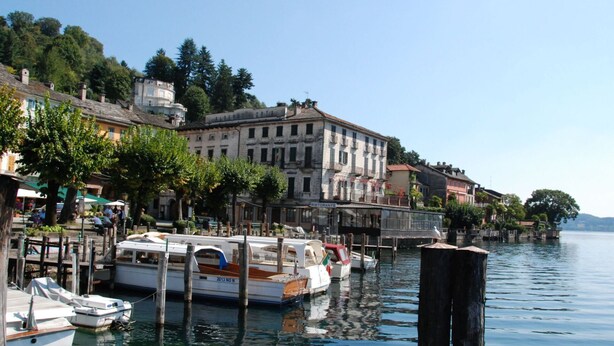A waterfront area with boats docked at a pier, buildings along the shore, and a clear view of the water. - Stunning private villa for 4 guests with WIFI, TV, patio and pets allowed (Armeno)