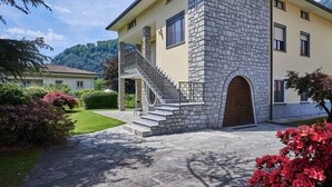A two-story house with a stone facade, a wooden door, and a staircase leading to a balcony. - Lovely apartment for 5 people with WIFI, TV, patio and pets allowed (Samolaco)