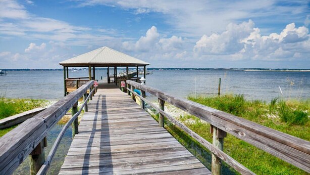 A wooden pier leading to a covered pavilion by the water. - Newly Renovated Home away from Home...Sandcastle Beach #43 (Navarre)