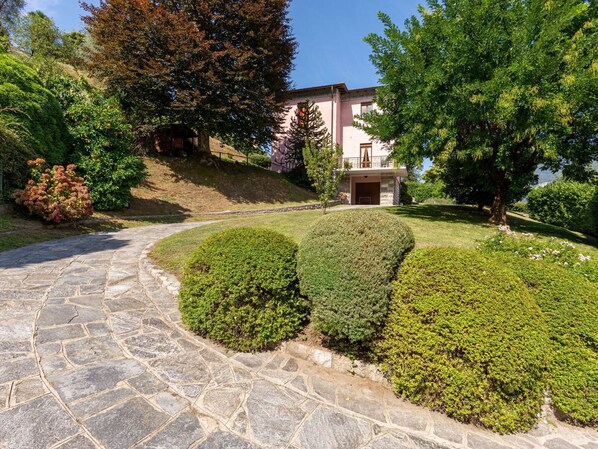 A stone pathway leading to a building with a stone facade and a small entrance.