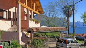 Un bâtiment à deux étages doté d’un balcon en bois, d’un patio couvert et offrant une vue sur la mer.