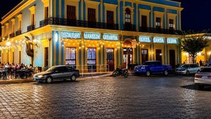 Un edificio con varios letreros que señalan que es restaurante, mansión, hotel y plaza.