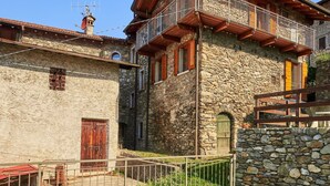 A stone building with a wooden balcony and a stone wall. - Beautiful private villa for 4 guests with WIFI, TV, patio and pets allowed (Peglio)