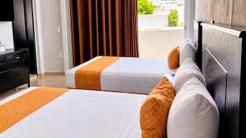 Habitación de hotel con dos camas, cabecero de madera, escritorio y vistas a la ciudad.