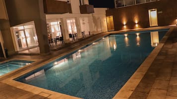 Alberca al aire libre y camastros