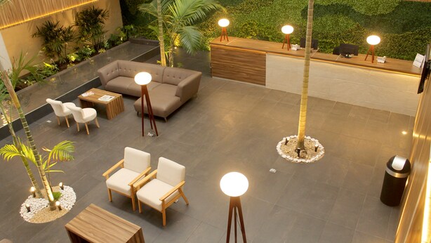 A modern lobby with a reception desk, seating area, and decorative plants. - Hotel Costa Verde (Veracruz)