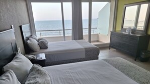 A hotel room with two beds, a dresser, and a view of the sea. - Hotel Costa Verde (Veracruz)