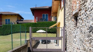 A gated entrance to a property with a paved pathway leading to a deck area. - Wonderful private villa for 3 people with pool, WIFI, A/C, TV, terrace and pets allowed (Sorico)