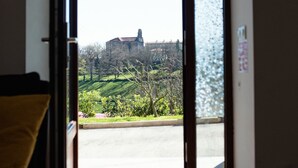 A room with a sliding glass door leading to an outdoor area with a view of a building and greenery. - Pico El Hayal - Apar located in a rural setting with 2 bedrooms, kitchen, living room and bathroom (Ampuero)
