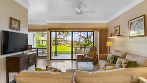 A spacious living room with a flat-screen TV, a sofa set, a coffee table, and a dining area with chairs. - Deluxe Ocean View Ground Floor.... Renovated ..Walk to the Hyatt and Beach...A/C (Koloa)