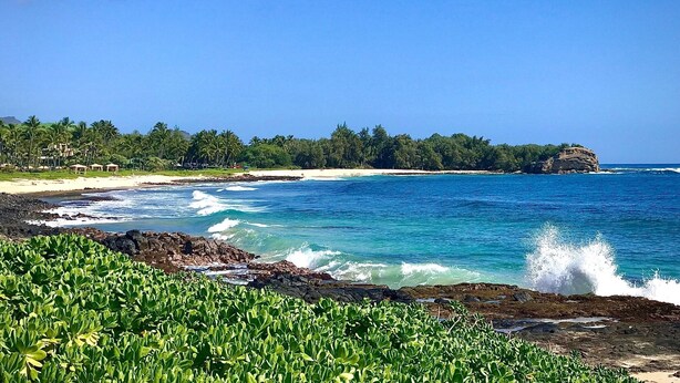 A coastal landscape with a beach, ocean waves, and a rocky shoreline. - Deluxe Ocean View Ground Floor.... Renovated ..Walk to the Hyatt and Beach...A/C (Koloa)