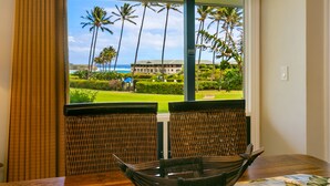 A dining area with wicker chairs and a view of a golf course and ocean. - Deluxe Ocean View Ground Floor.... Renovated ..Walk to the Hyatt and Beach...A/C (Koloa)