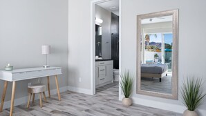 A modern bedroom with a large mirror, a desk, and a view of a balcony. - Modern Escape, La Quinta Cove #259116, 4 BR (La Quinta)