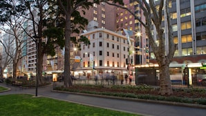 A multi-story building with a central courtyard, surrounded by trees and a well-maintained lawn. - The Occidental Hotel (Sydney)